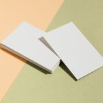 Stack of blank white business cards on pastel surface offering copy space for design.