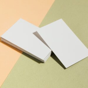 Stack of blank white business cards on pastel surface offering copy space for design.